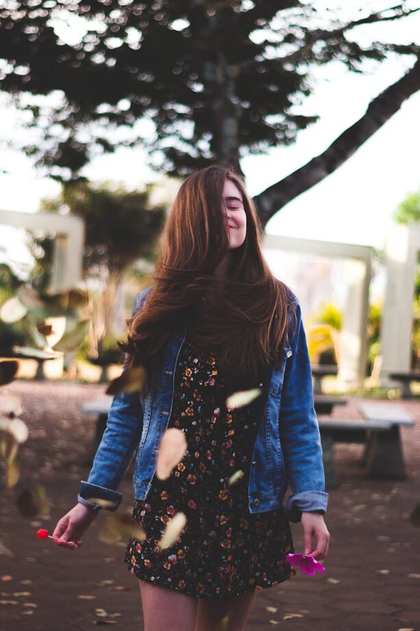 "Selective focus portrait of a woman holding a flower and lollipop, symbolizing gentle self-confidence"
