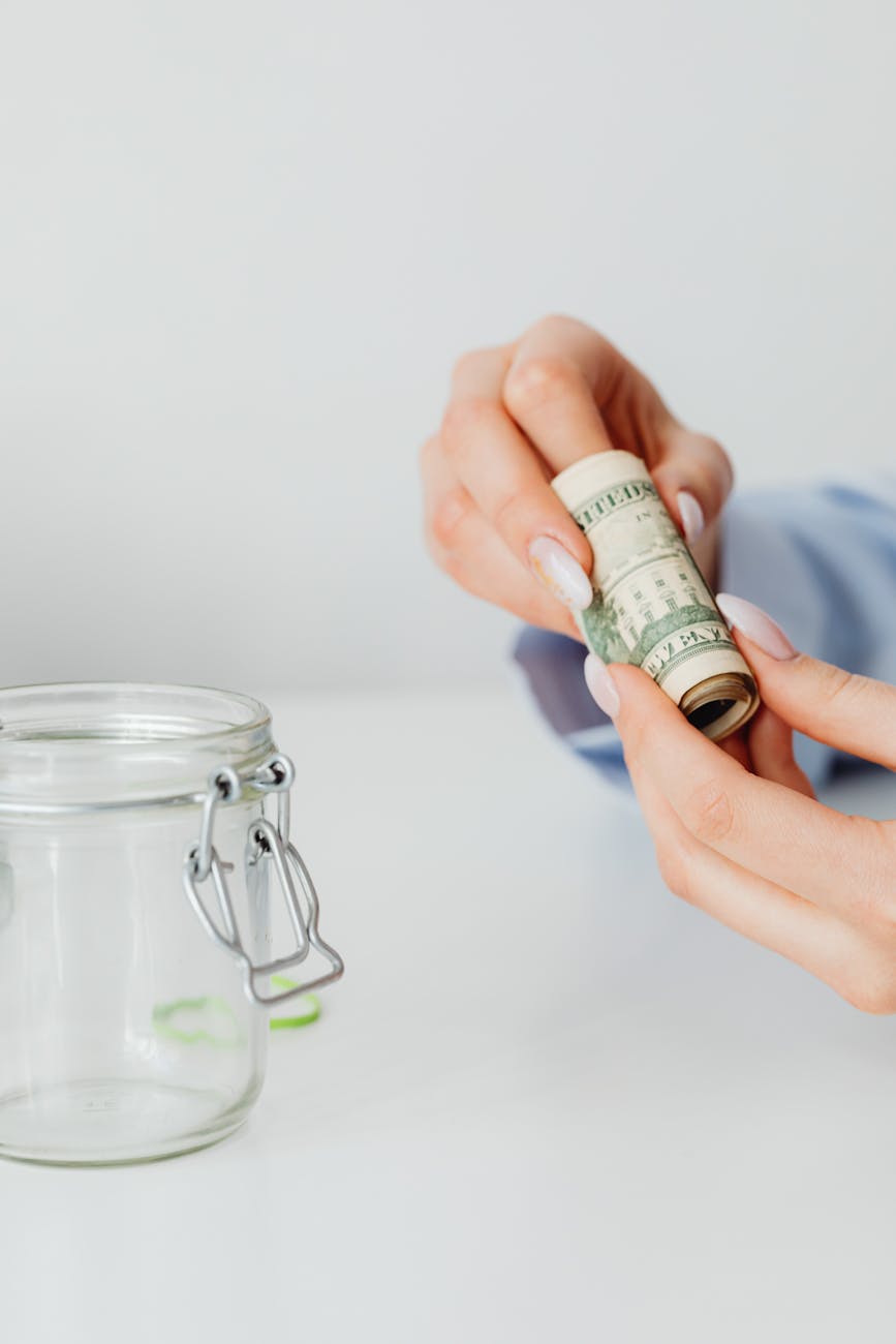 a person holding rolled paper money